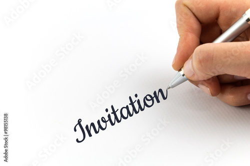 Hand writing "Invitation" on white sheet of paper.