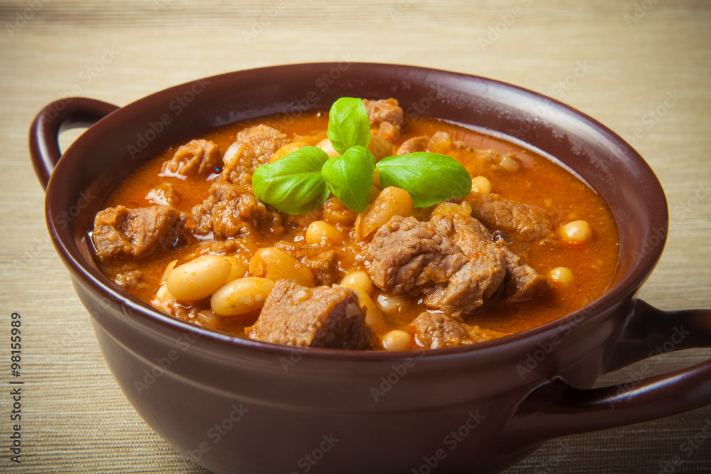 Traditional turkish meal - Kuru fasulye in a clay bowl on a ligh Traditional turkish meal - Kuru fasulye in a clay bowl on a ligh