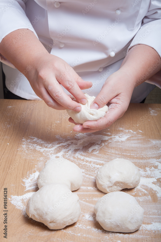 Woman's hands knead dough. Selective focus