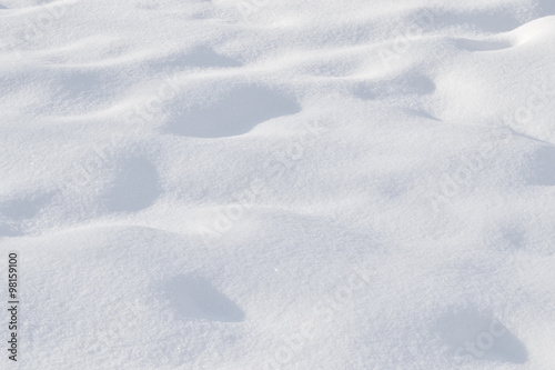 Snow, undulating surface. The background, texture. Rough, wavy surface of the snow. The top layer of snow fluffy and fresh. 