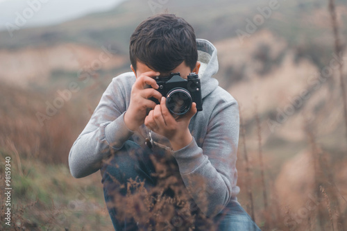 Young boy shooting with vintage camera