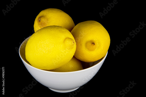 Whole Lemons in White Bowl on Black Background