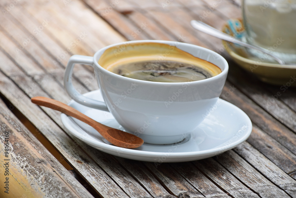 One full cup of Americano coffee on bamboo table One full cup of Americano coffee on bamboo table