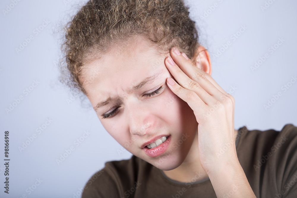 Portrait of little girl suffering from headache and holding hands on her head.Stressed little girl having problems. Portrait of little girl suffering from headache and holding hands on her head.Stressed little girl having problems.