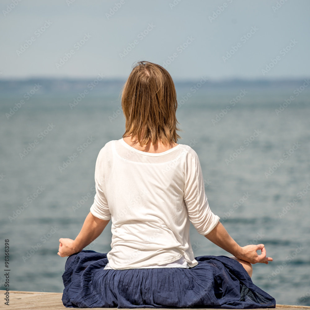 Woman meditating at the sea