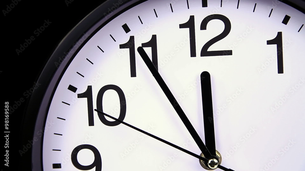Wall clock on a black background 23:55 close-up