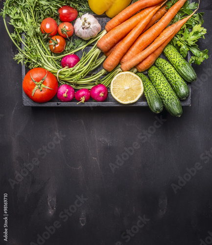 fresh carrots cherry tomatoes, garlic, cucumber, lemon, pepper, radish, wooden spoon salt pepper colored, oil wooden rustic background top view close up border, place for text 