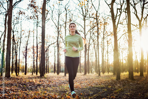 Fototapeta Naklejka Na Ścianę i Meble -  young sporty caucasian female running in autumn park