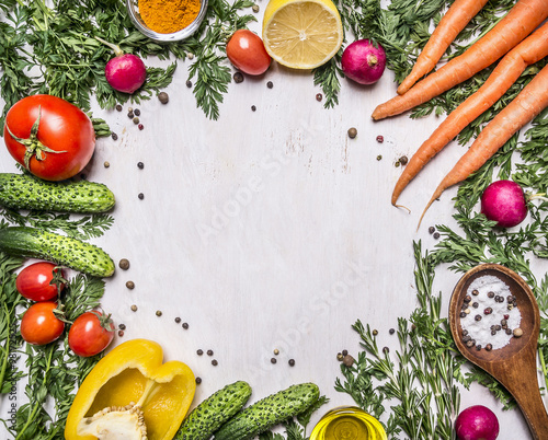 Healthy foods, cooking and vegetarian concept fresh carrots with cherry tomatoes, garlic, lemon radish, peppers, cucumbers, butter on wooden rustic background top view