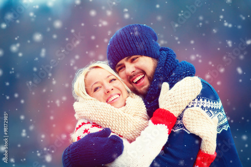 happy couple having fun under winter snow