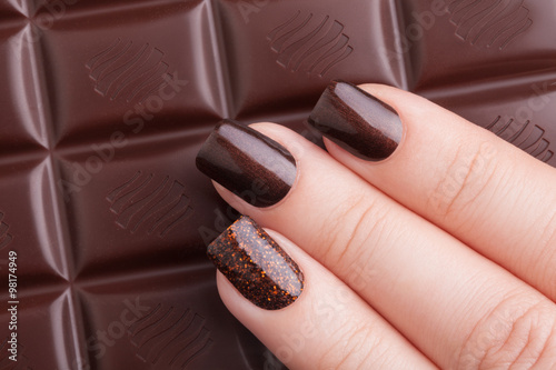 Brown nail polish on the nails.