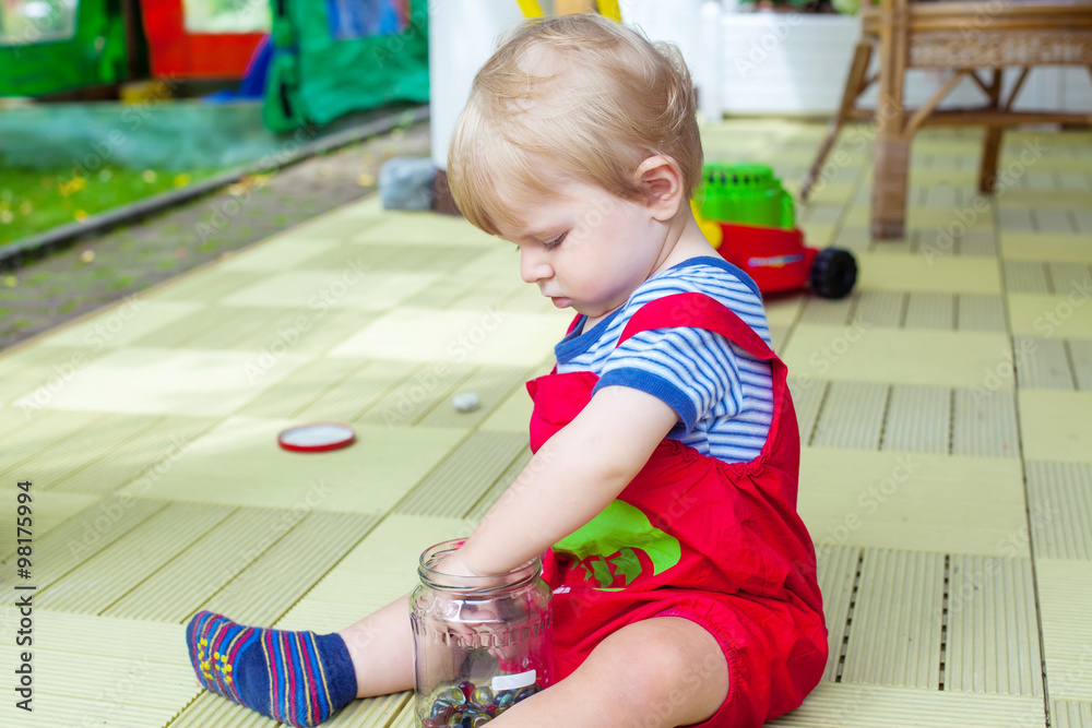 Little boy one year old playing with colorful marbles Little boy one year old playing with colorful marbles