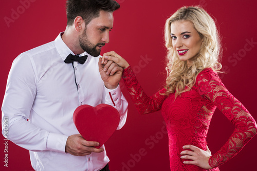 Man with heartshape box holding woman's hand.