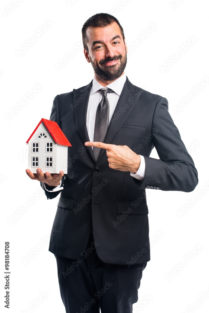 Businessman holding a little house Businessman holding a little house