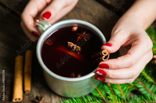 Cup with mulled wine in the hands of a girl