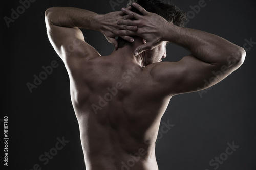 Fototapeta Handsome muscular bodybuilder posing on gray background