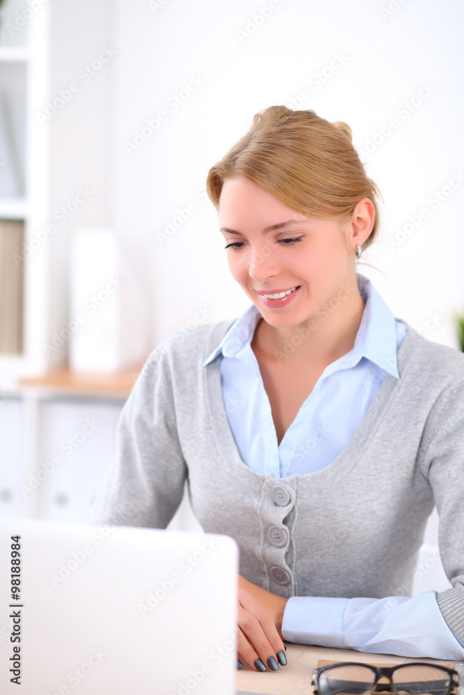 Young blonde business woman with laptop in the office. Business concept.