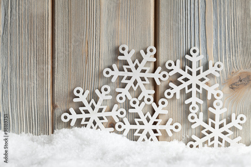 Snowflakes on snow and wooden background