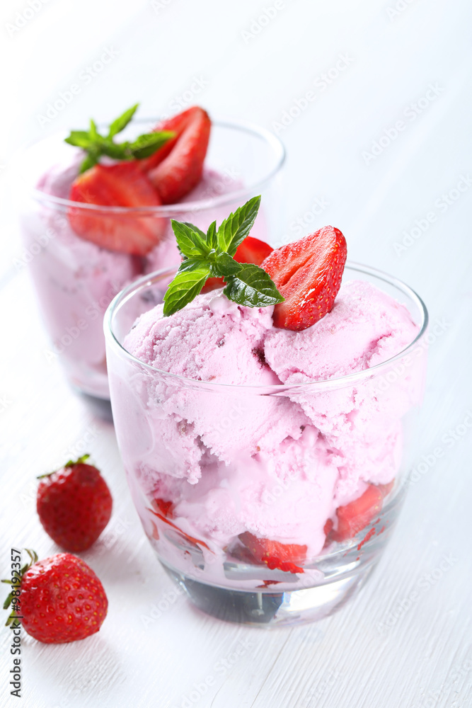 Ice cream in glasses with strawberries on white wooden backgroun Ice cream in glasses with strawberries on white wooden backgroun