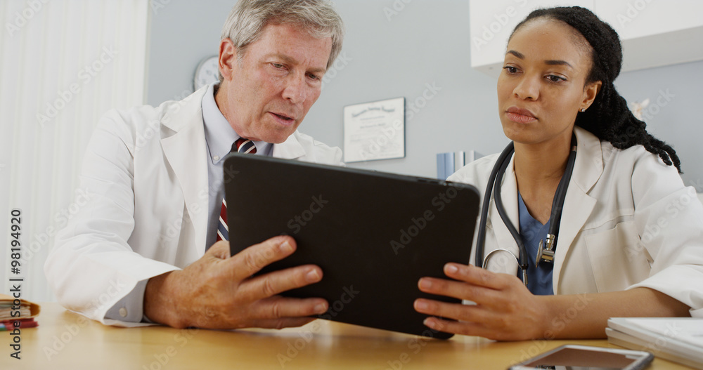 Hardworking doctors reviewing patient's file Hardworking doctors reviewing patient's file