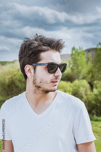 Boy with black sunglasses in Iraqi meadow during spring season