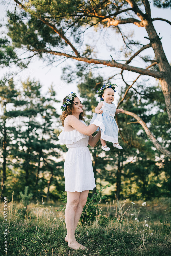 Fototapeta premium mother and two daughter in summer whisk at sunset