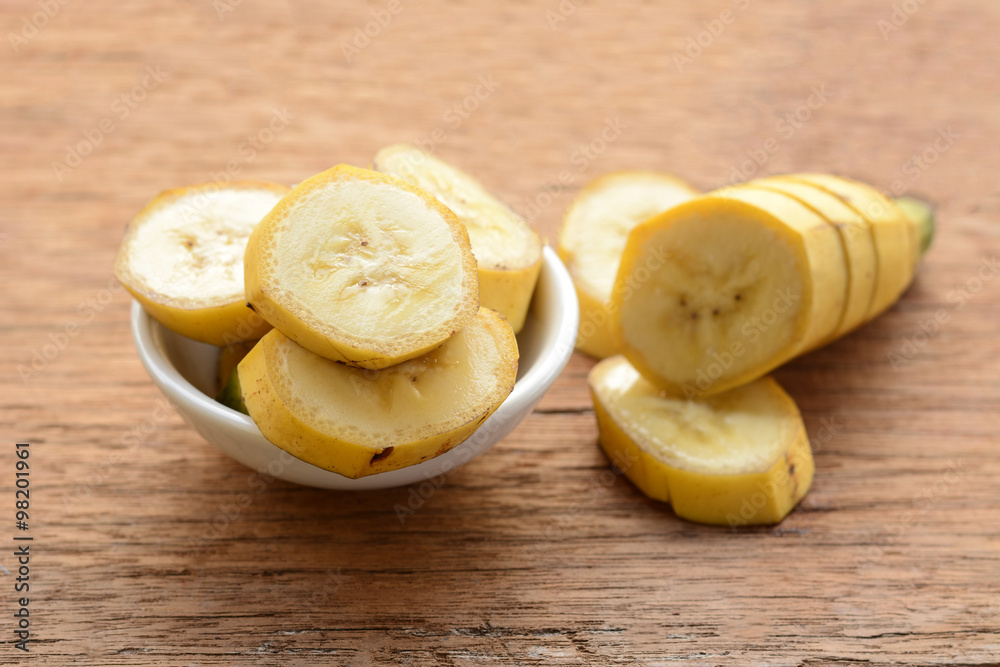 sliced banana in a cup over a table.