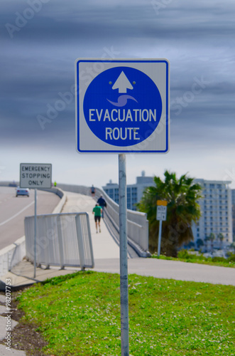 Emergency Evacuation Route sign with looming storm clouds in the background