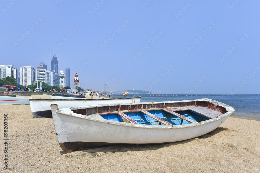Fototapeta premium White wooden row boat on a sunny beach.