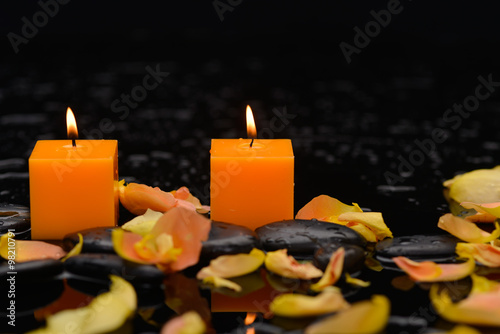 rose petals with two candle and therapy stones 