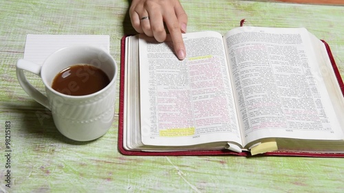 Hands of Young Woman reading over Bible
