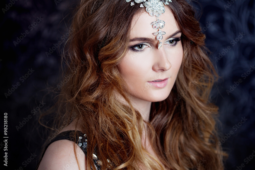 beautiful girl with long brown curled hair, dark background beautiful girl with long brown curled hair, dark background