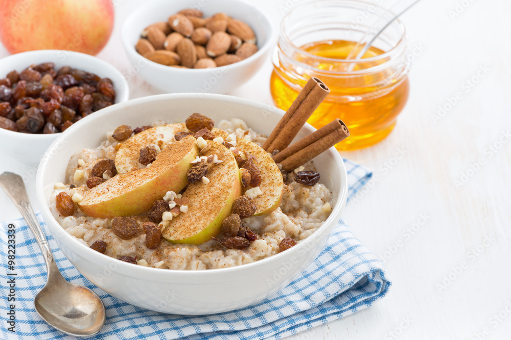 oatmeal with apples, raisins and cinnamon for breakfast on white oatmeal with apples, raisins and cinnamon for breakfast on white