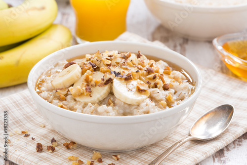 oatmeal with banana, honey and walnuts in bowl for breakfast