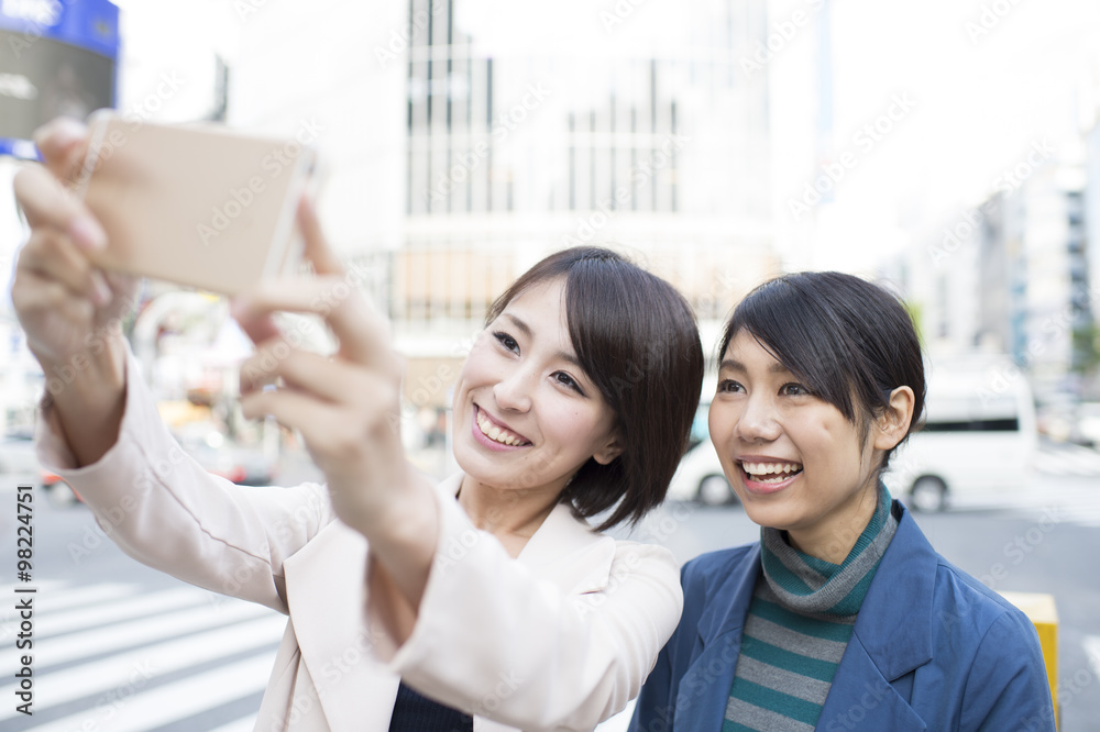 Women have a commemorative photo with your friends in the smartphone Women have a commemorative photo with your friends in the smartphone