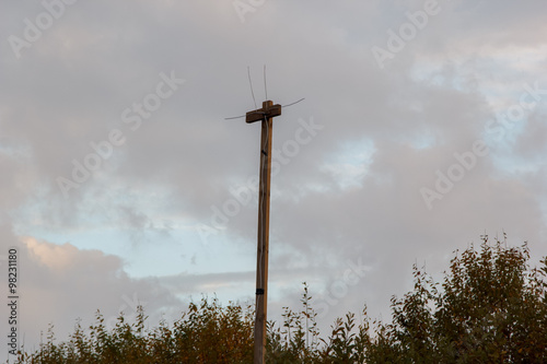 homemade TV antenna on a pole against evening sky