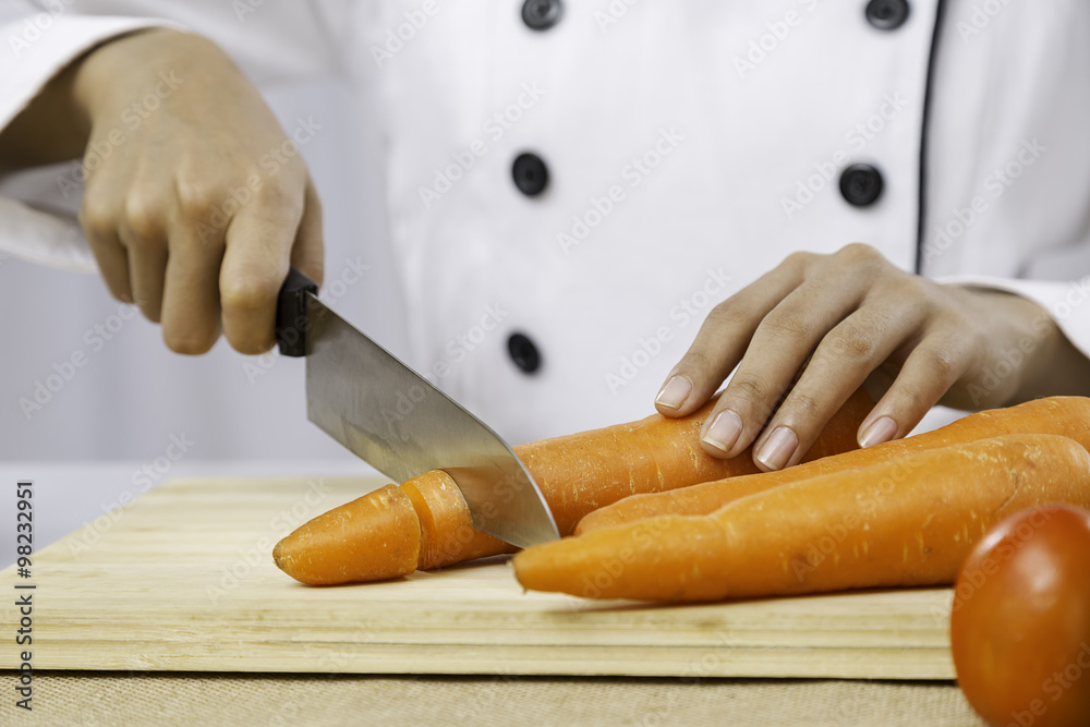 Obraz premium close up of chef’s hand chopping a carrot