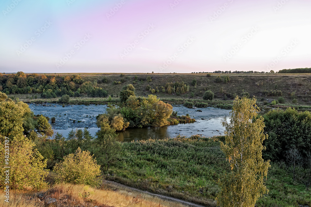Obraz premium River with rapids at sunset
