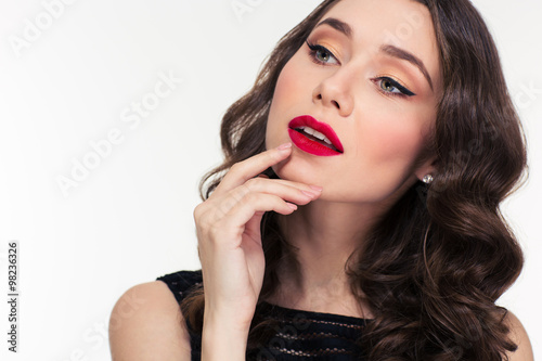 Thoughtful attractive curly woman with bright makeup in retro style