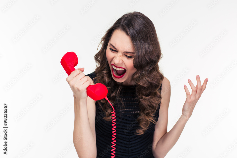 Crazy raged retro styled female shouting in red telephone receiver Crazy raged retro styled female shouting in red telephone receiver