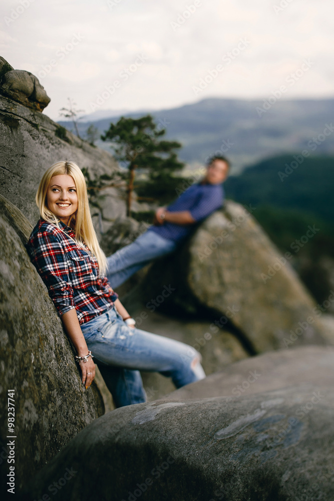 Naklejka premium Young beautiful couple in jeans and shirts for a walk in the mou