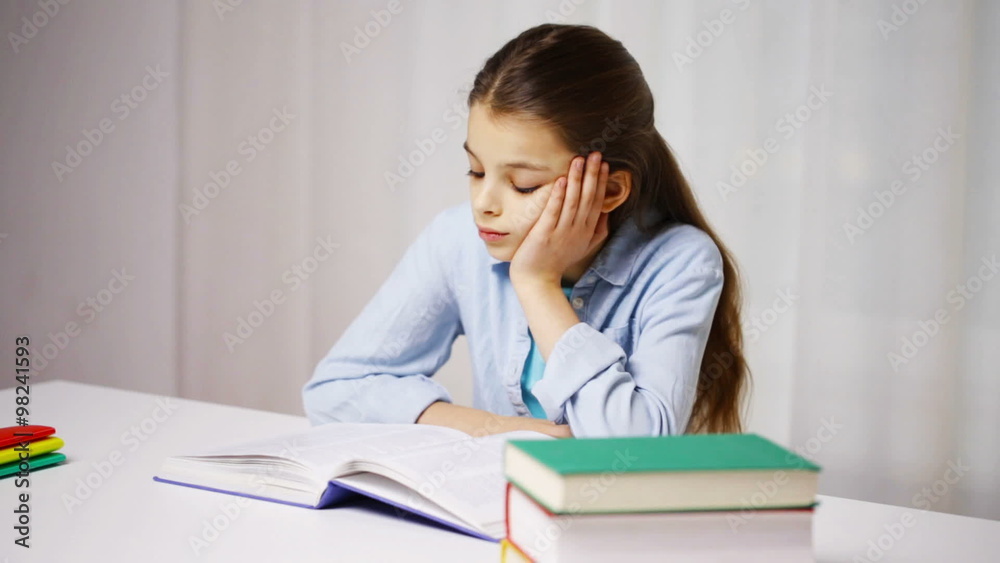 bored school girl reading book or textbook at home bored school girl reading book or textbook at home
