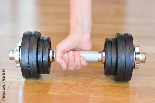 Woman pumping up muscles Lifting Dumbbell at home