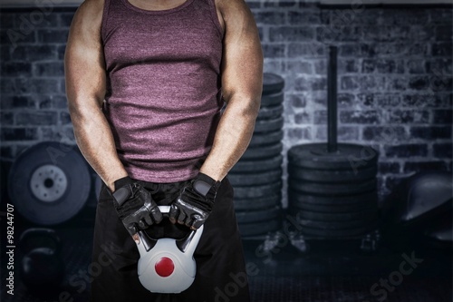 Composite image of fit man exercising with kettlebell