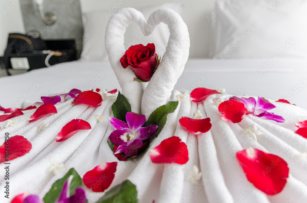 Naklejka premium Honeymoon decoration with towels and rose petals