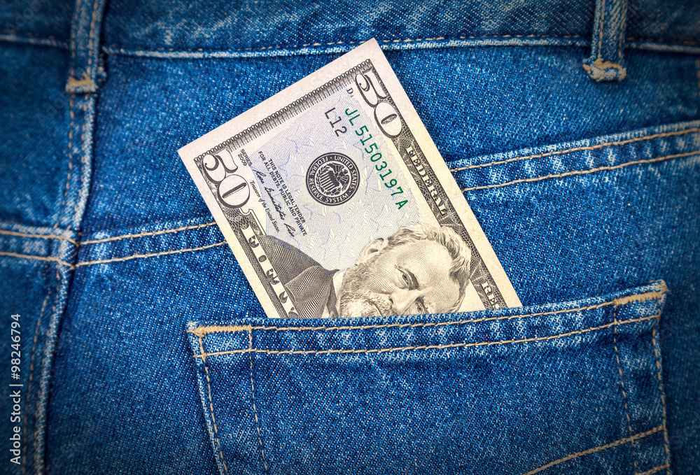 Fifty dollars bill sticking out of the blue jeans pocket Fifty dollars bill sticking out of the blue jeans pocket