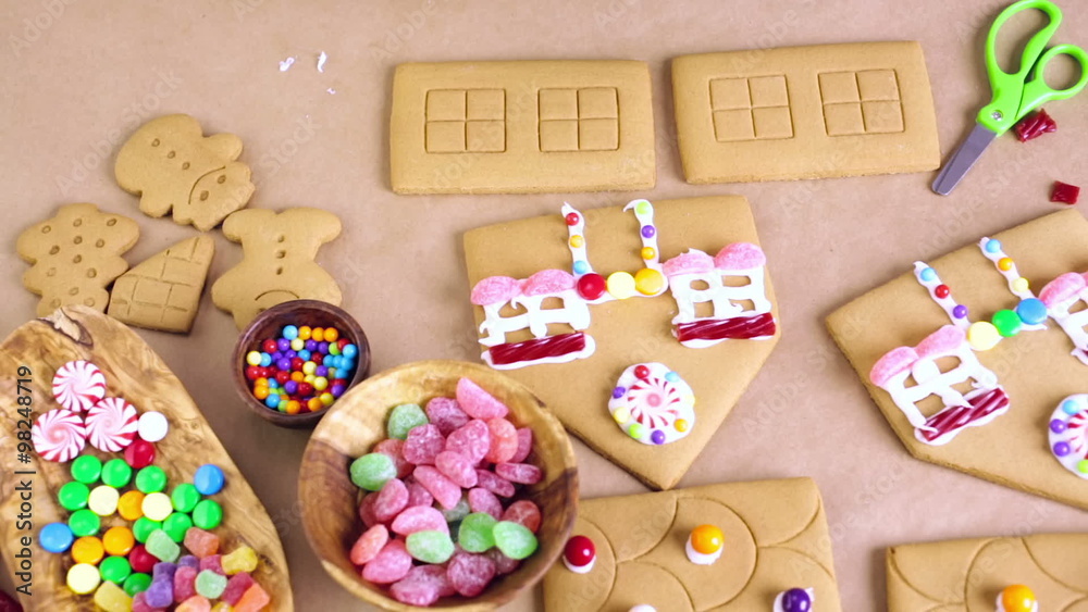 Decorating gingerbread house with royal icing and colorful candies