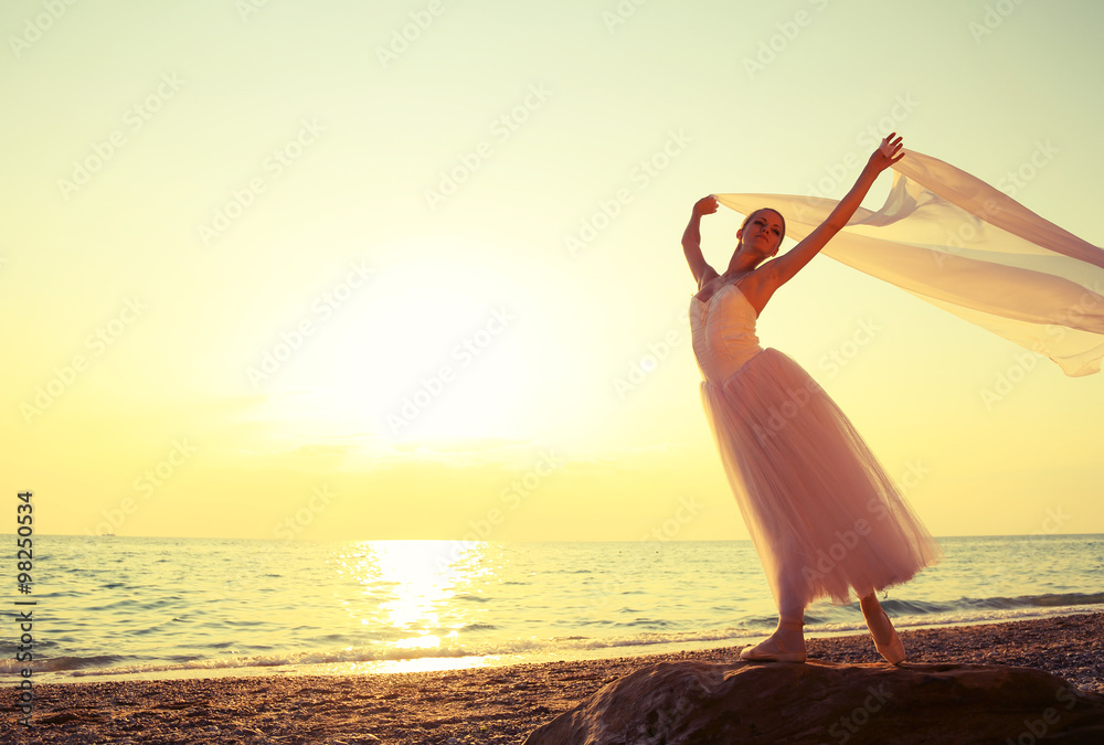 ballet dancer with a veil at sunset on the coast