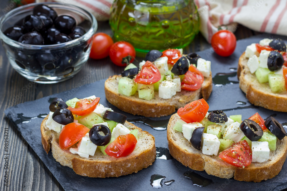 Greek style crostini with feta cheese, tomatoes, cucumber, olives and herbs