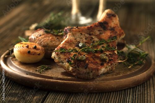 Grilled pork chop with spices, garlic and onions.